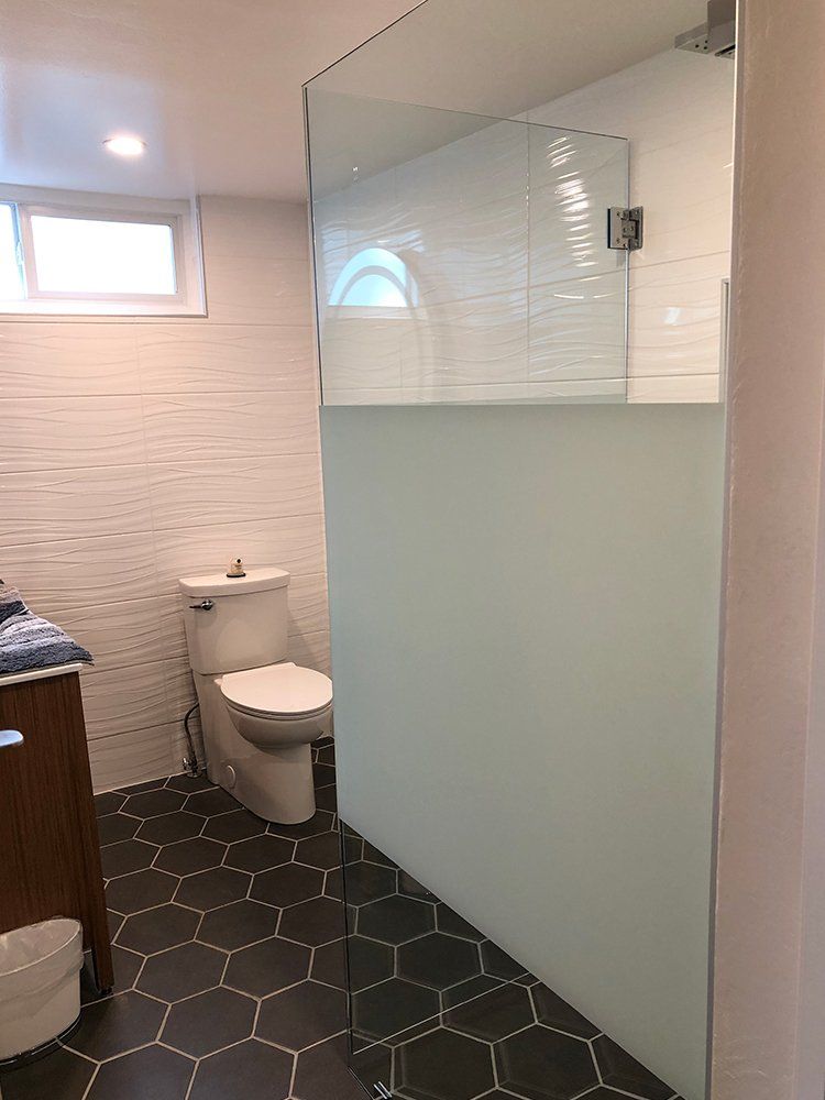 A bathroom with a toilet, sink and shower stall