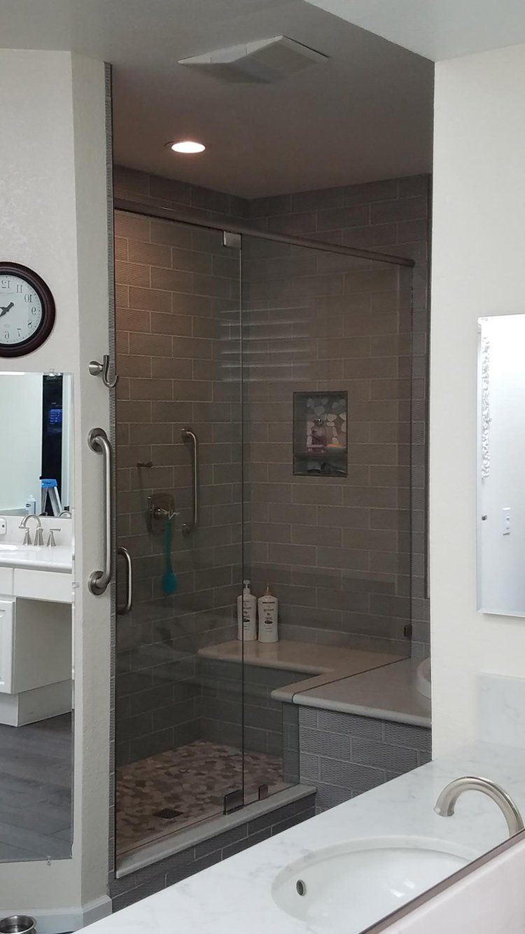 A bathroom with a walk in shower, bathtub, sink and mirror