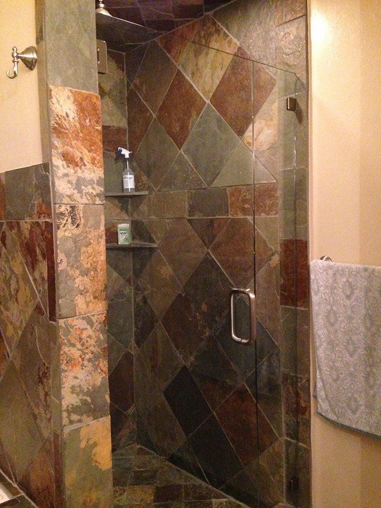 A bathroom with a walk-in shower and a towel hanging on the wall