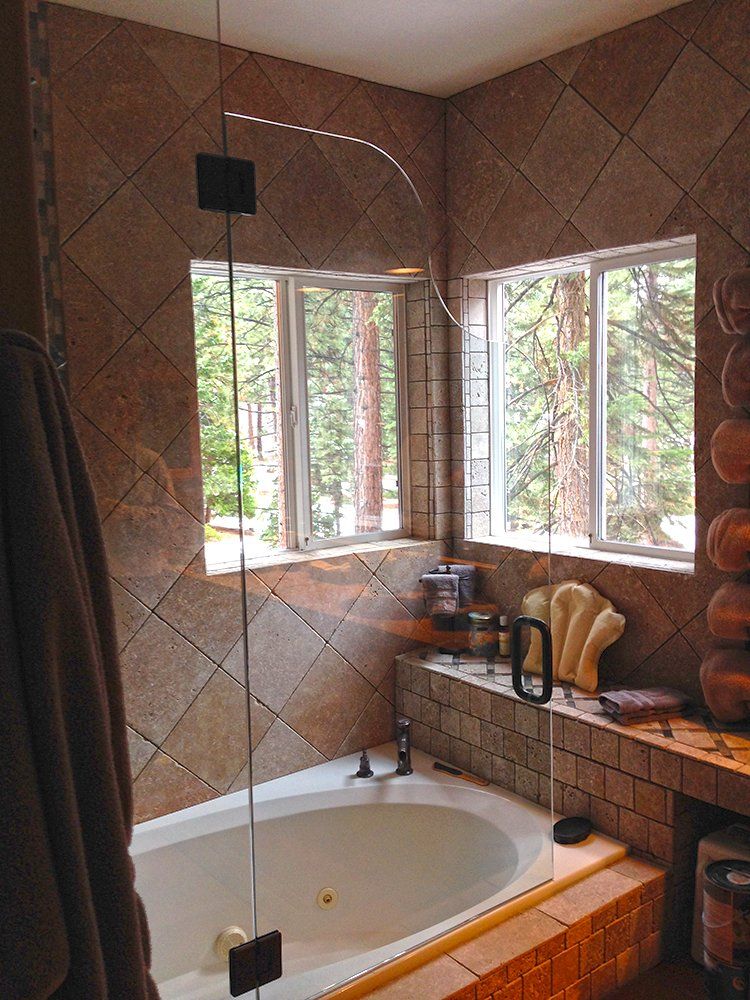 A bathroom with a tub and a shower with a glass door