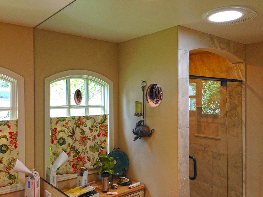 A bathroom with two mirrors and a light on the ceiling