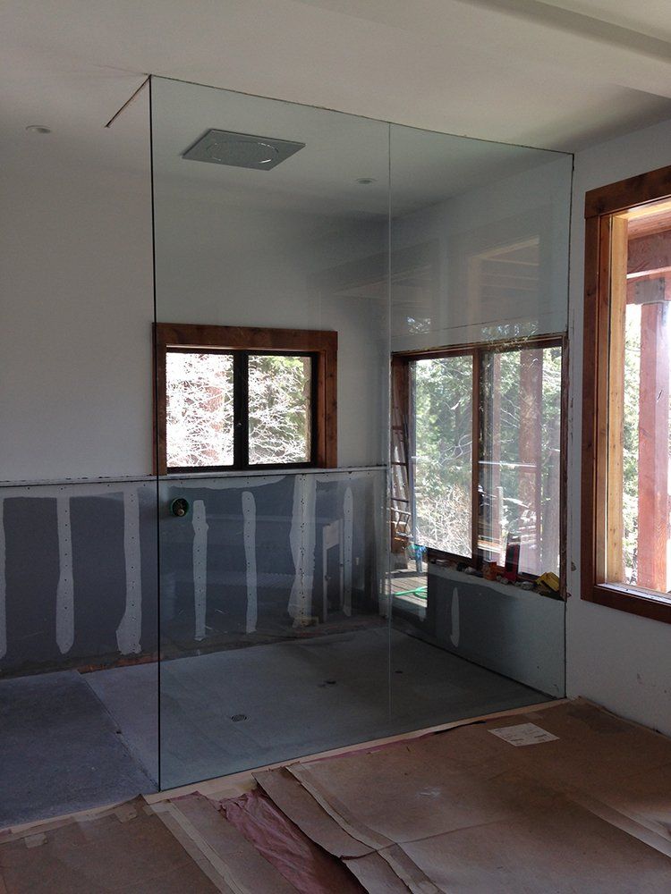 A bathroom with a glass shower door and a window