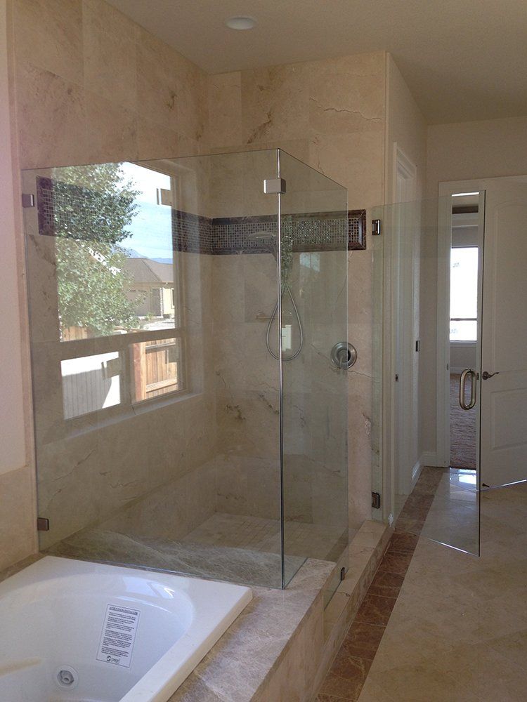 A bathroom with a tub and a shower with a glass door