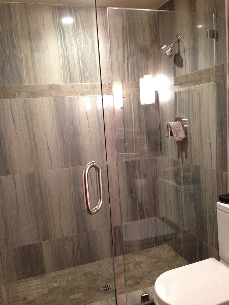 A bathroom with a toilet and a shower with a glass door