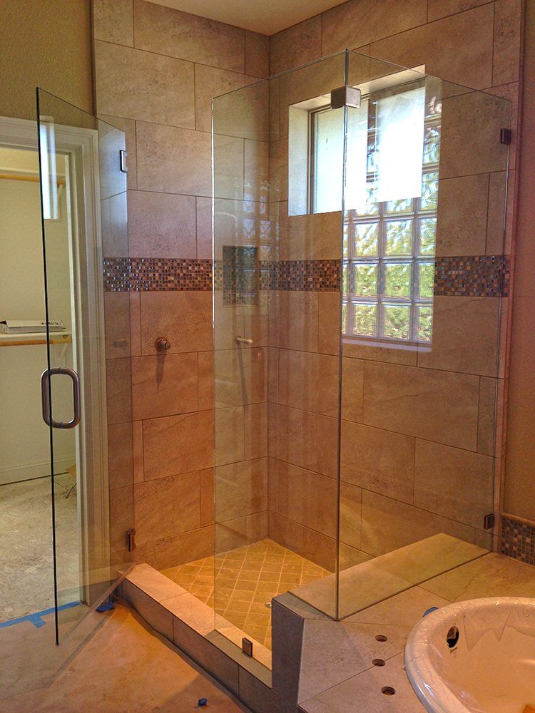 A bathroom with a walk in shower and a tub
