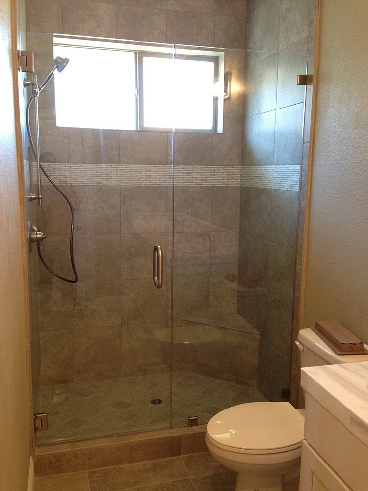 A bathroom with a toilet and a shower with a glass door
