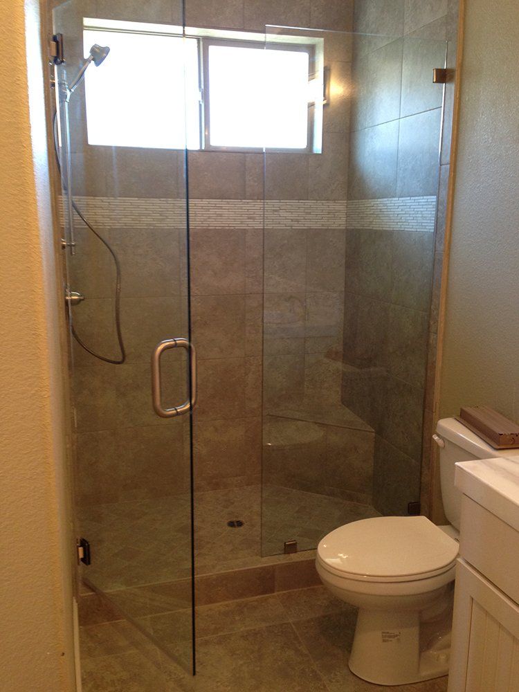 A bathroom with a toilet and a shower with a glass door