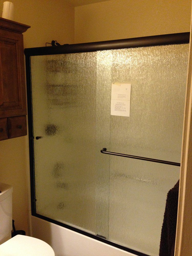 A bathroom with a sliding glass shower door