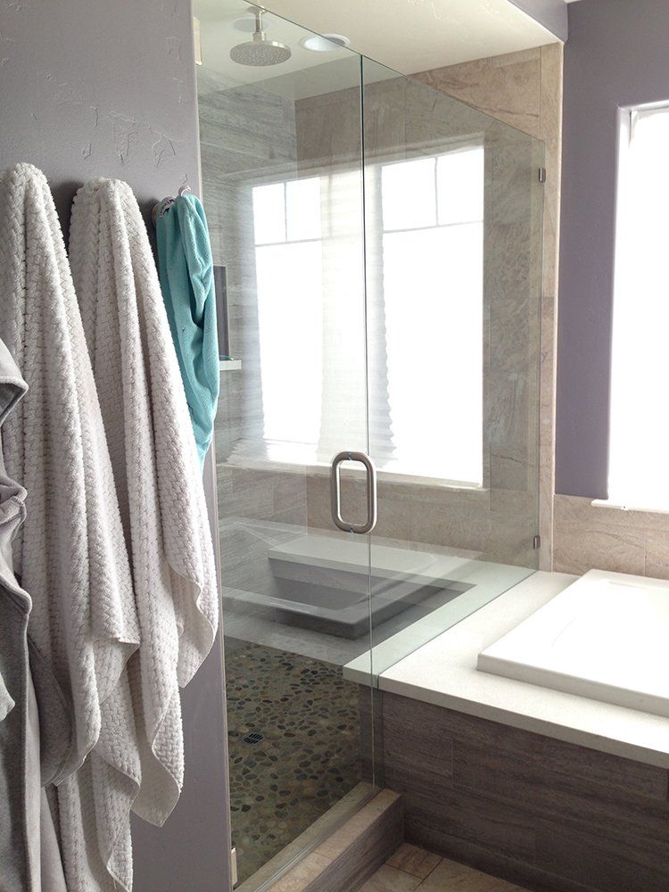 A bathroom with a glass shower door and a bathtub