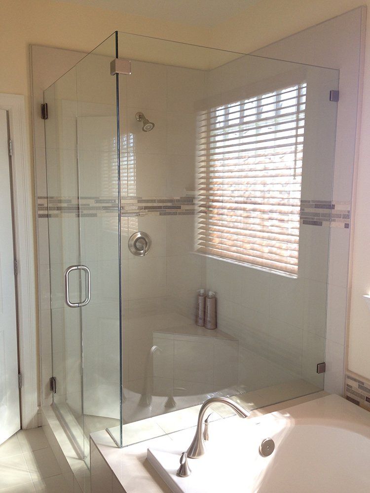 A bathroom with a glass shower door and a bathtub