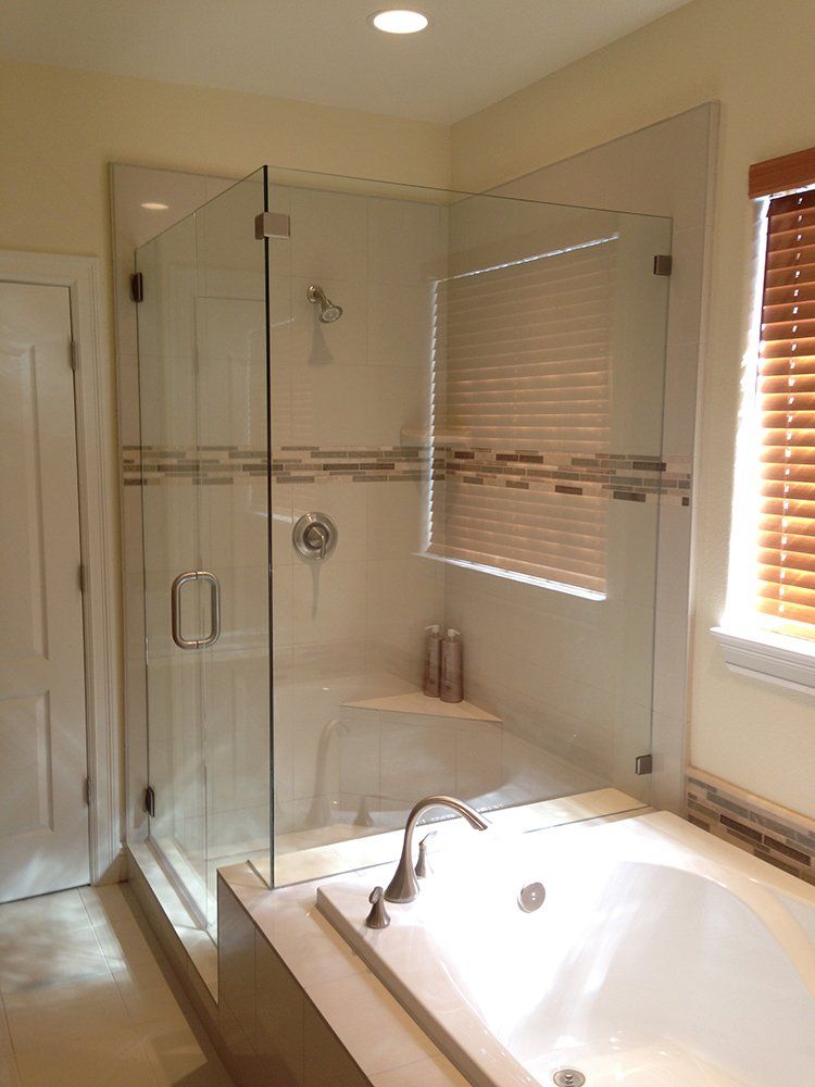 A bathroom with a tub, shower and window