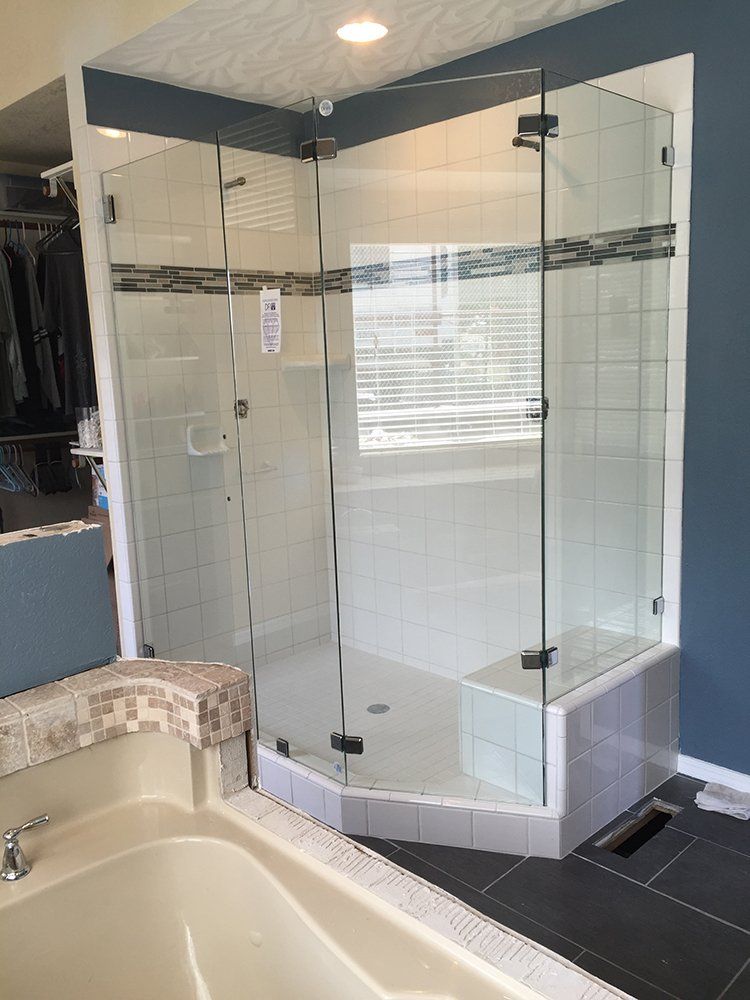 A bathroom with a bathtub and a shower stall with glass doors