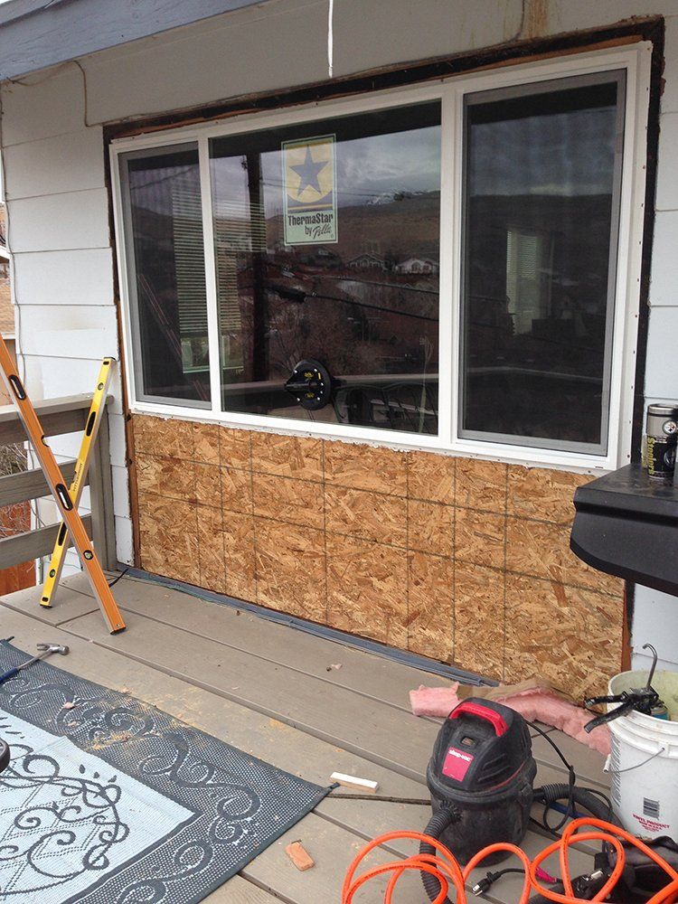 A window is being installed on the side of a house