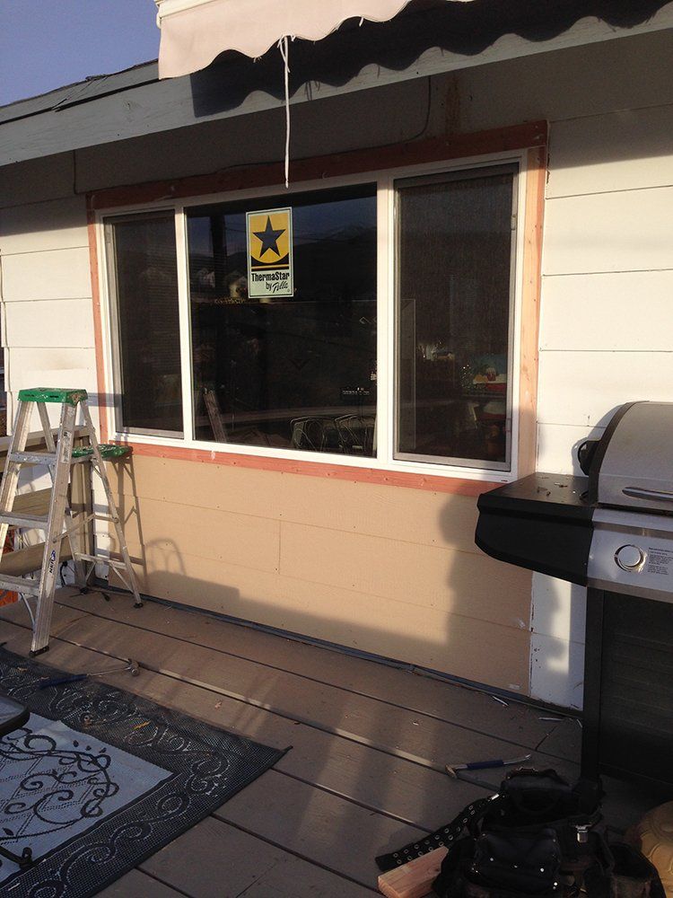 A house with a large window and a grill in front of it