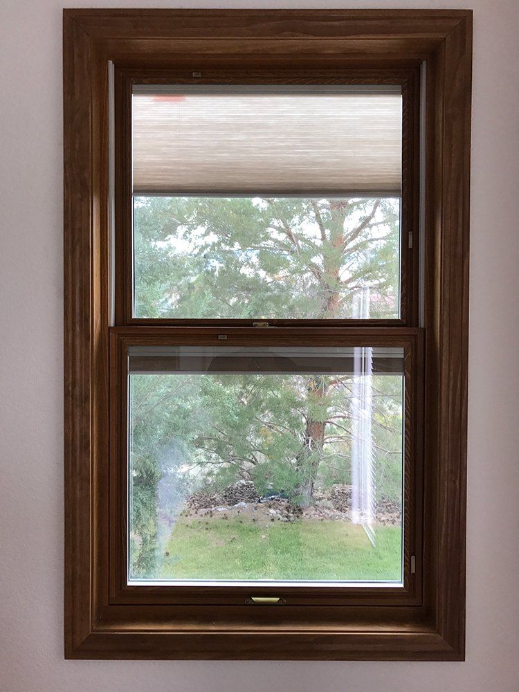 A window with a wooden frame and a honeycomb blind