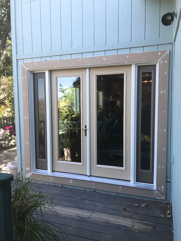 A sliding glass door is being installed on the side of a house