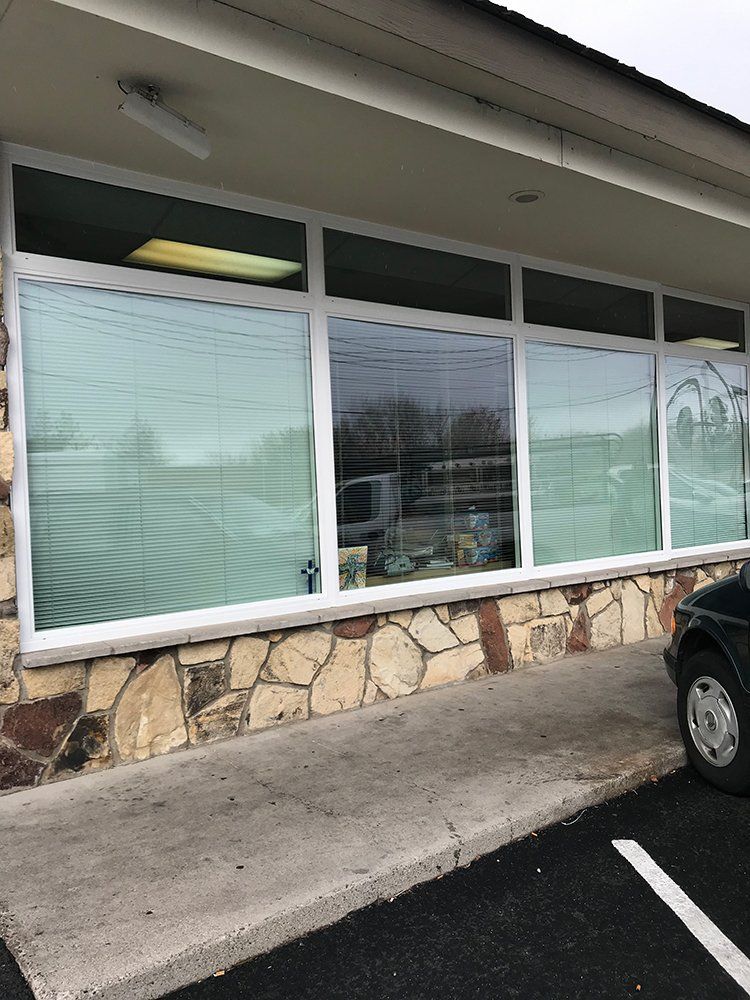 A car is parked in front of a building with a lot of windows