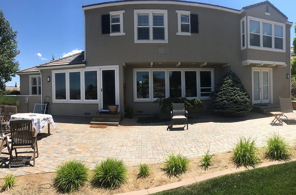 A large house with a patio and chairs in front of it