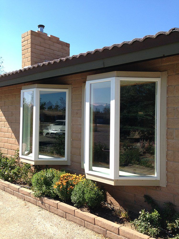 A brick house with two bay windows and a chimney