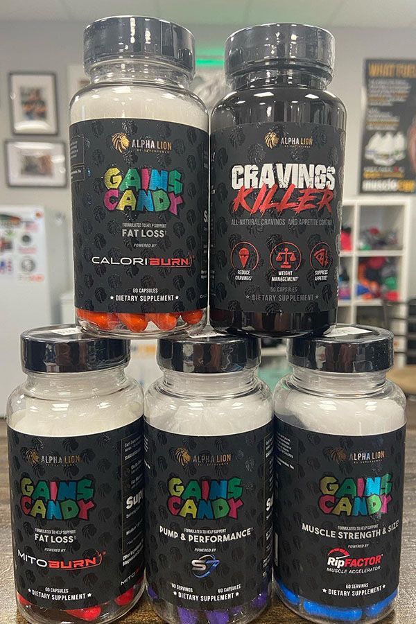 Four bottles of gains candy are stacked on top of each other on a table.