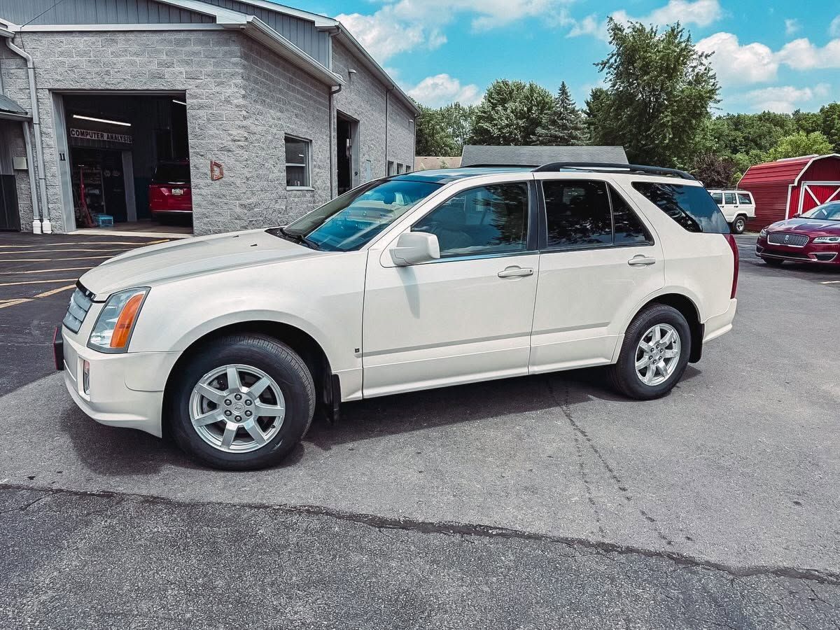 White SUV parked beside a gray service building on a sunny day