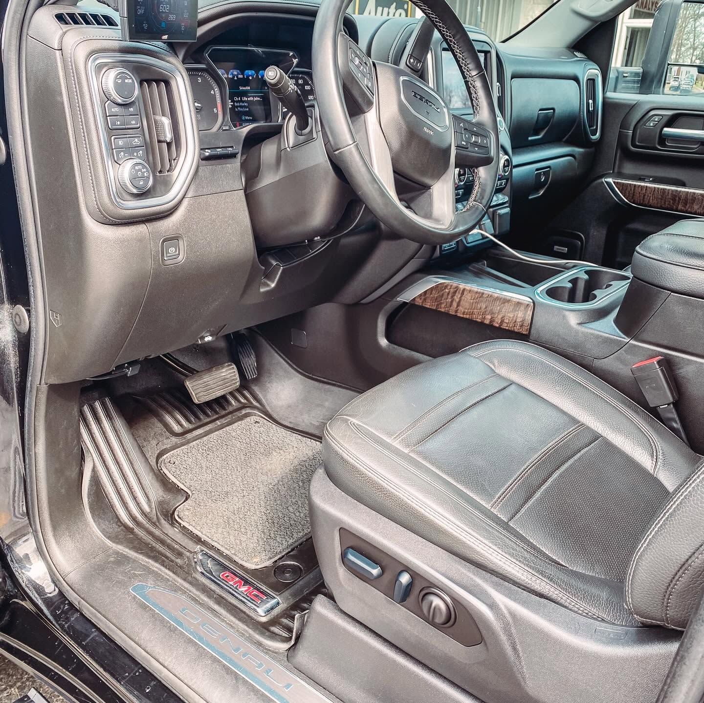 Black leather truck interior showing the driver’s seat, steering wheel, dashboard, and center console.