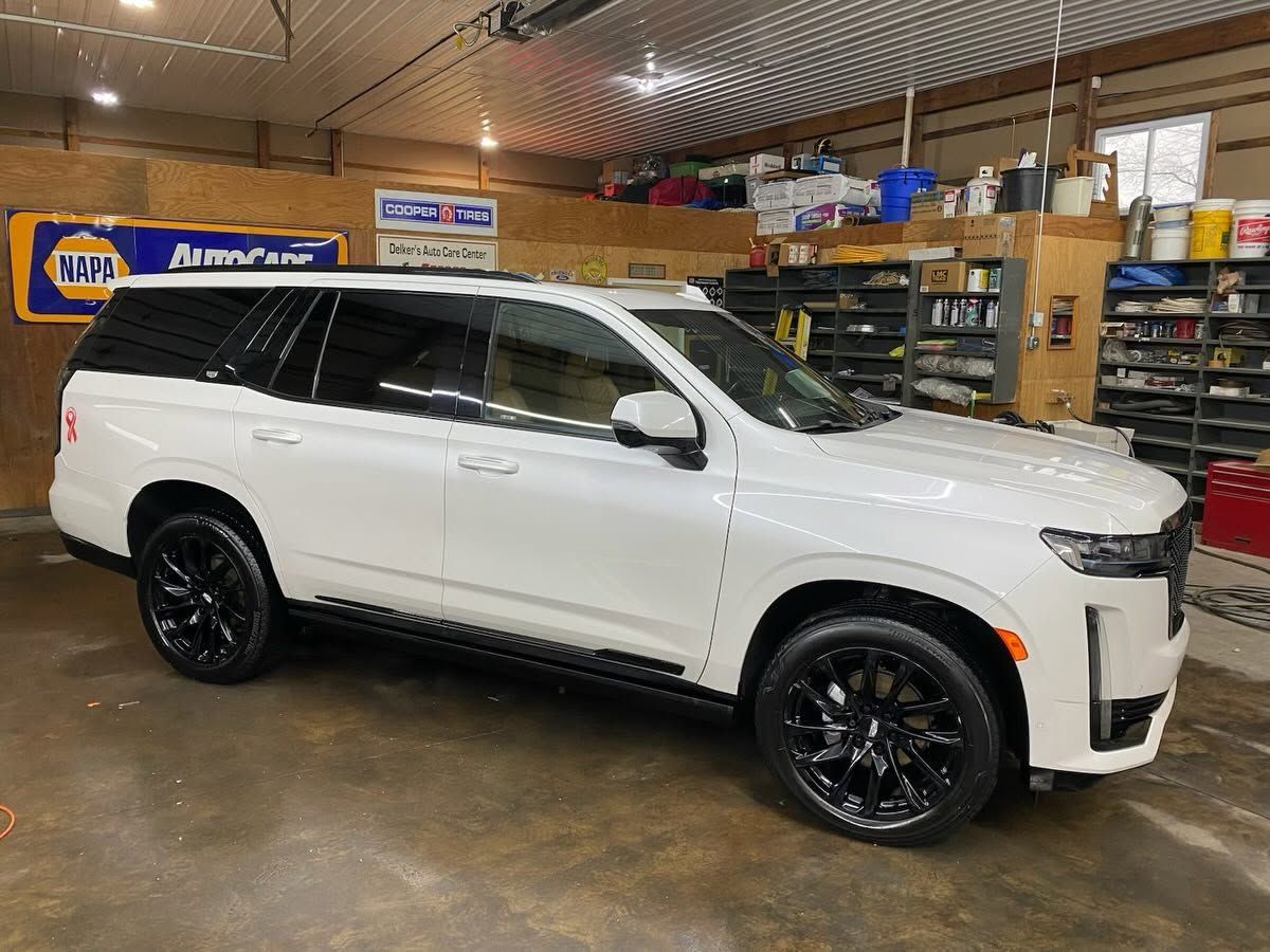 White SUV parked in a garage with black wheels and tinted windows
