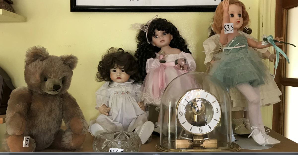 3 dolls a teddy bear and a clock