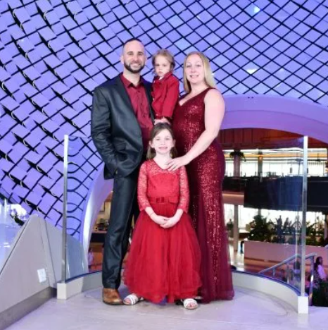A family in formalwear posing on an indoor staircase