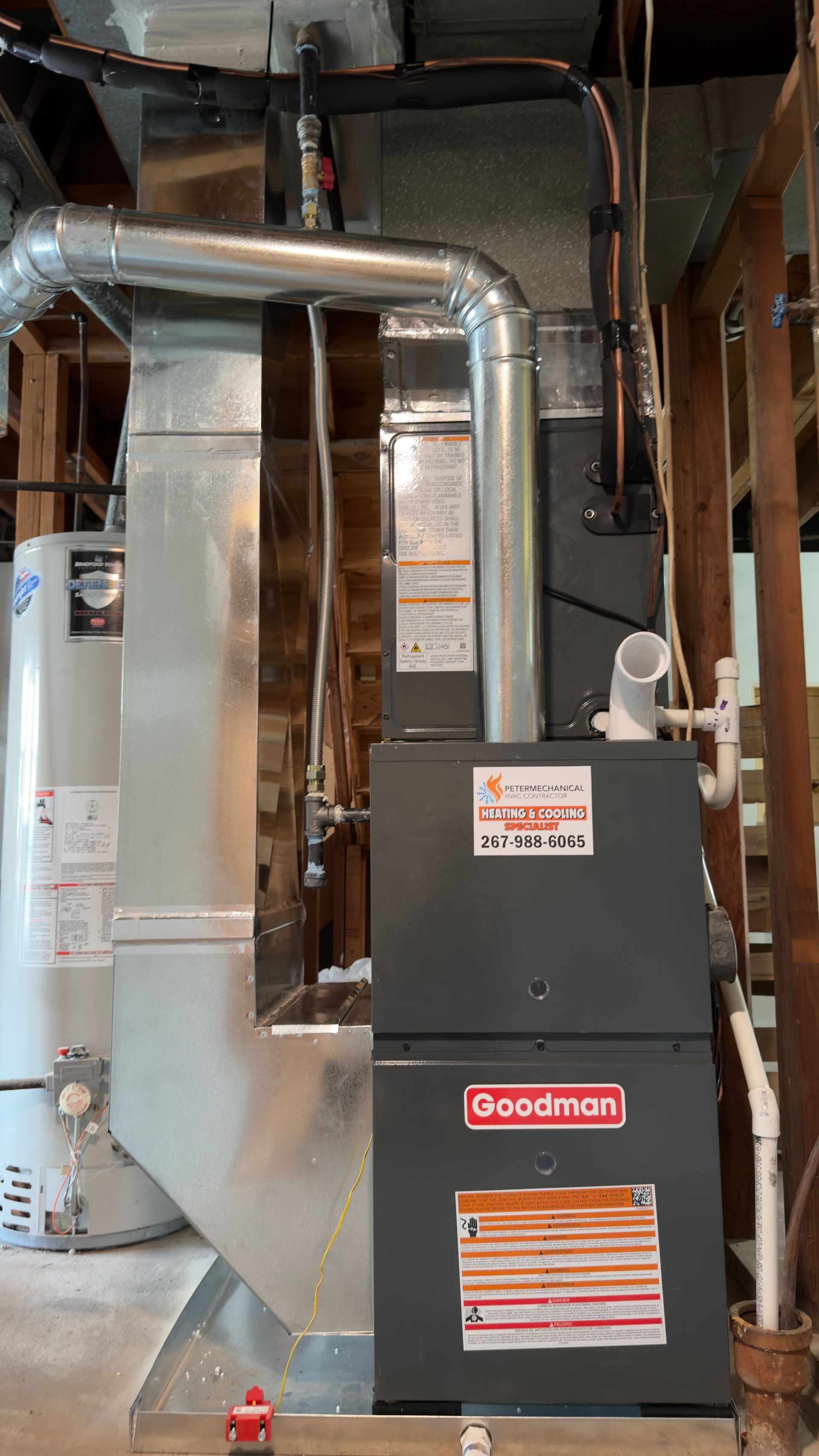 Silver HVAC ductwork and a Goodman furnace in a utility room with exposed framing