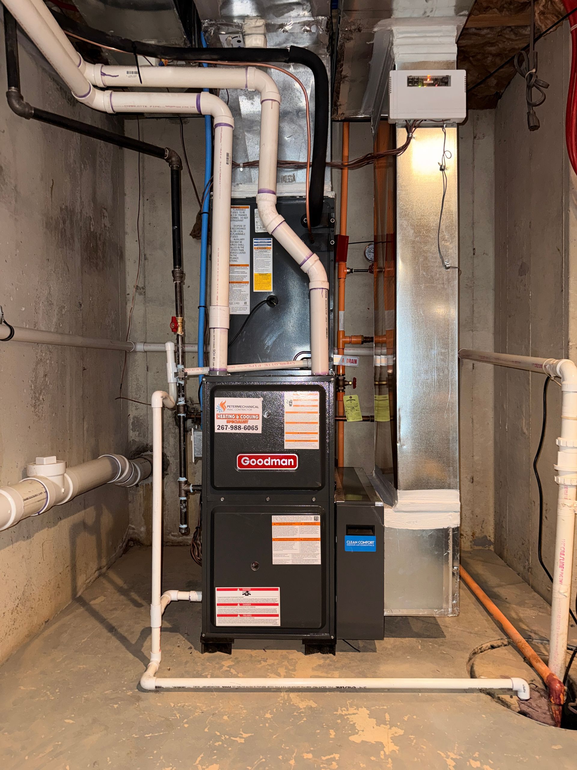Basement mechanical room with furnace, metal ductwork, and exposed pipes.