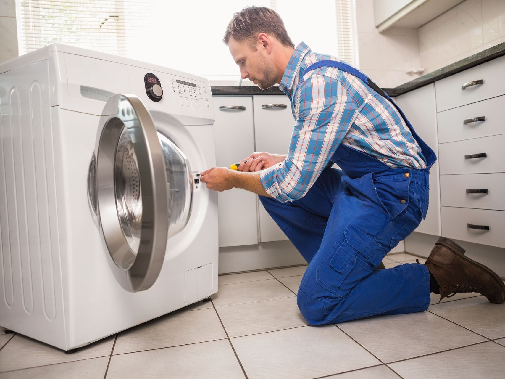 Learn More About Our Services Man fixing washer