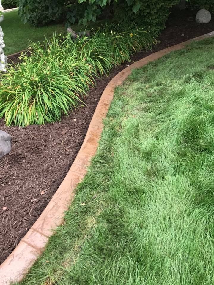 there is a concrete curb in the middle of the lawn .