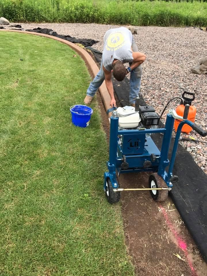 a man is working on a lawn with a machine .