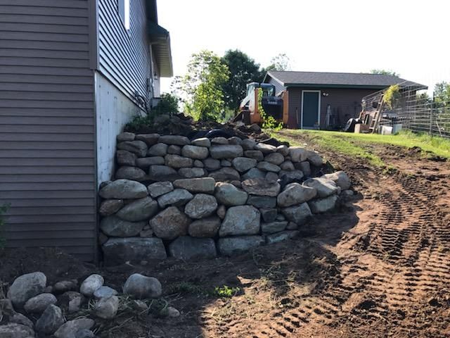 a stone wall is being built in front of a house .
