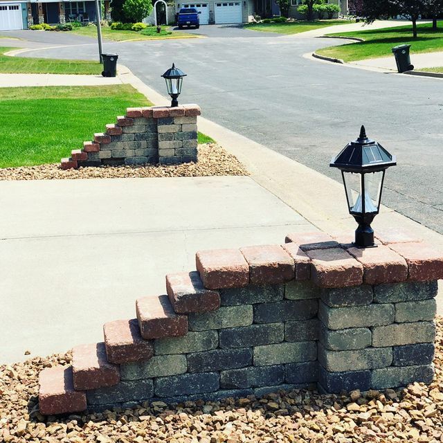 a brick wall with stairs and a lamp on it