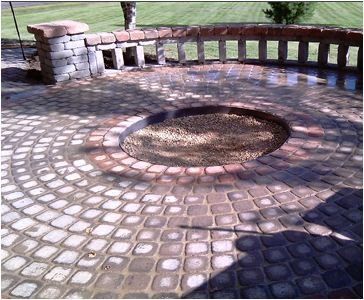 a brick patio with a fire pit in the middle