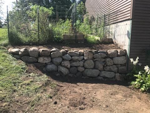 a stone wall is being built in front of a house .