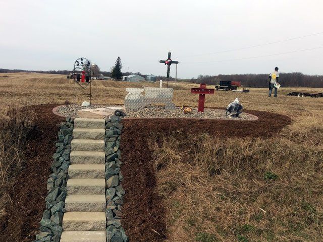 a graveyard with stairs and a cross in the middle of a field .