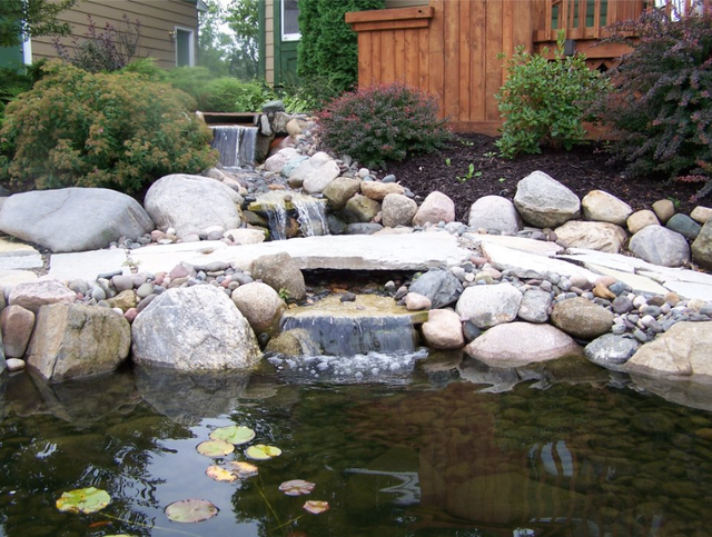 a pond with a waterfall in the middle of it