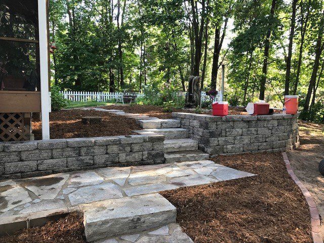 a stone walkway with steps leading up to a screened in porch .