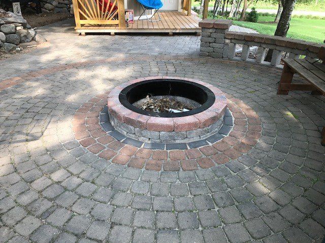 a fire pit is surrounded by bricks on a patio .