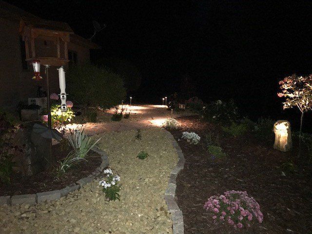 a path leading to a house is lit up at night .
