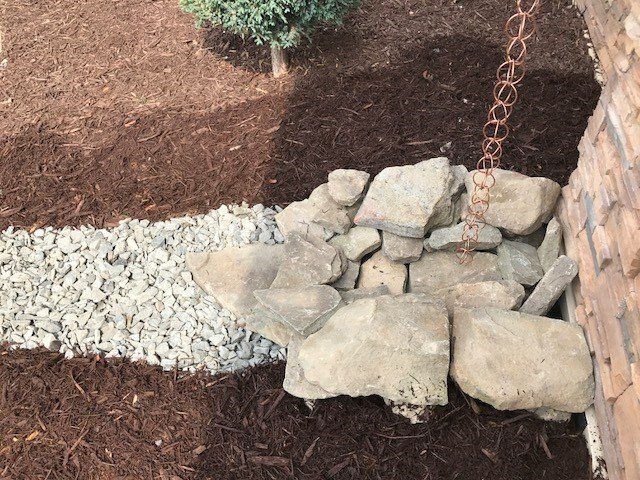 a pile of rocks is sitting next to a brick wall .