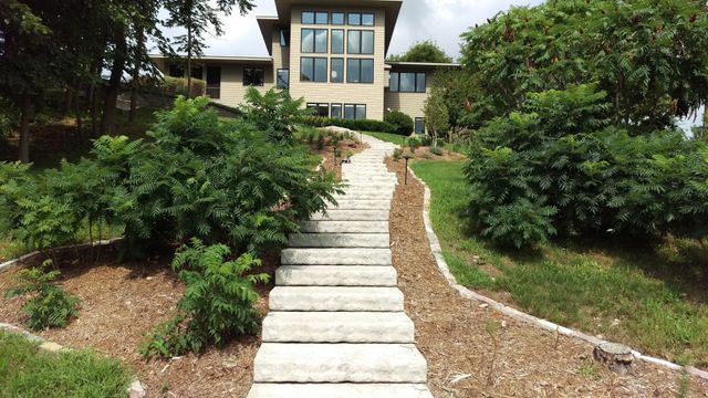 a set of stairs leading up to a large house surrounded by trees .