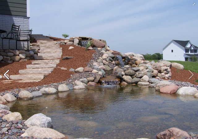 a pond with a waterfall in the middle of it