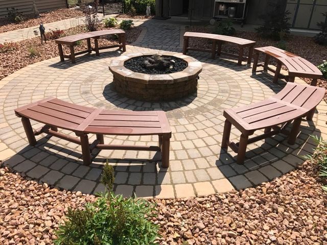 a fire pit surrounded by wooden benches on a patio