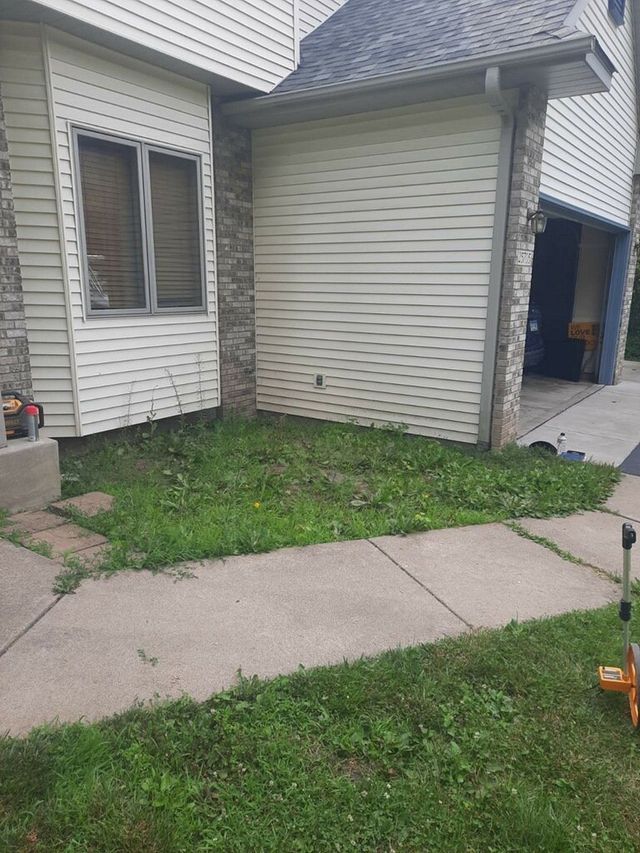 a house with a lawn mower in front of it .