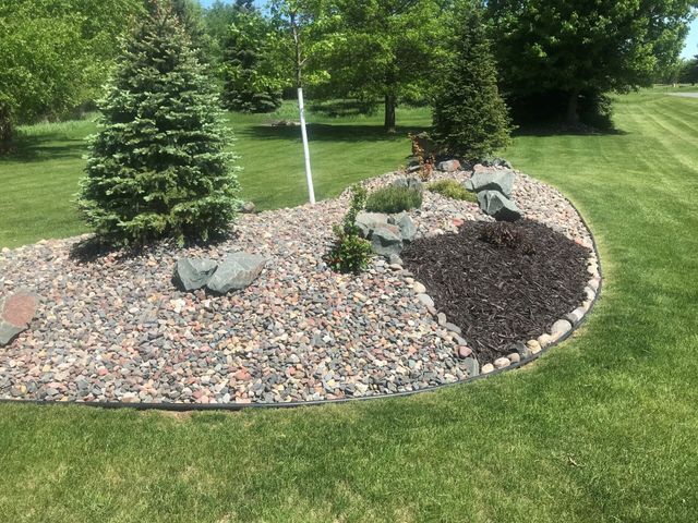 a lush green lawn with a rock garden in the middle of it .