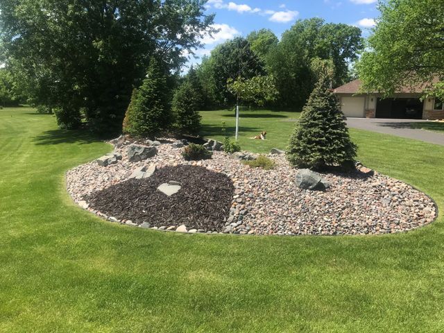 a lawn with a heart shaped rock in the middle of it